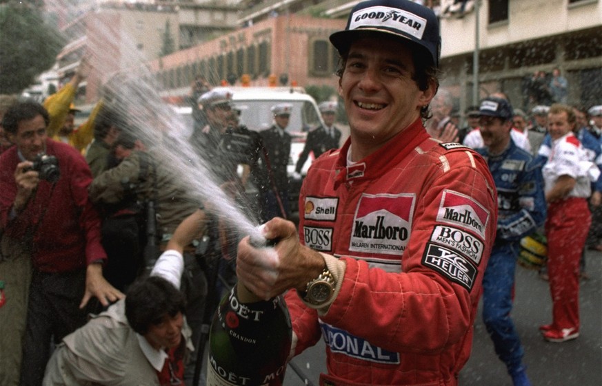 FILE - In this May 12, 1990, file photo, Brazilian driver Ayrton Senna sprays champagne on the photographers to celebrate his career's 30th victory at the Monaco Formula One Grand Prix May 12, 1990. B ...