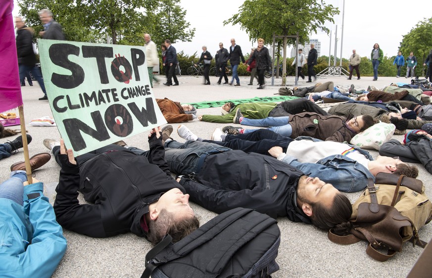 epaselect epa07574714 Demonstrators protest for more climate and environmental protection with a so-called &#039;die-in&#039; at the Annual General Meeting of the automobile manufacturer BMW in Munich ...