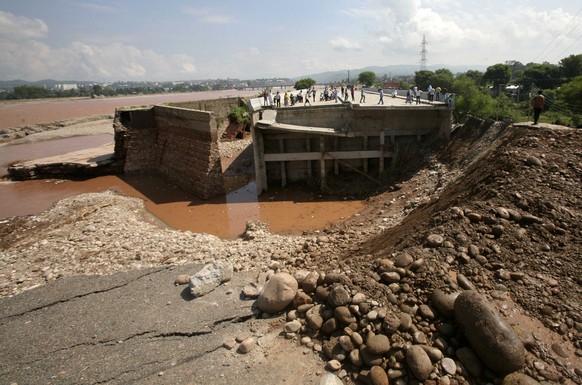 Einwohner begutachten eine eingestürzte Brücke in der Region Jammu.