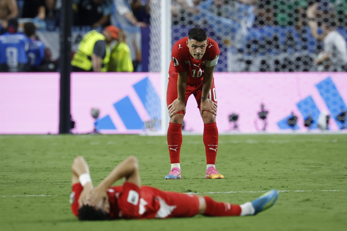 Switzerland's Granit Xhaka, back, and Ruben Vargas, front, look dejected after the World Cup quarter final match between Argentina and Switzerland at the Kansas City Stadium in Kansas City, USA,  ...