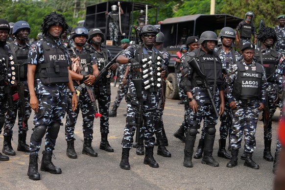 FILE - Nigeria police officers stand guard during a candle light procession in honour of all protesters killed nationwide at the recently economic hardship protest, in Lagos, Nigeria, Friday, Aug. 9,  ...