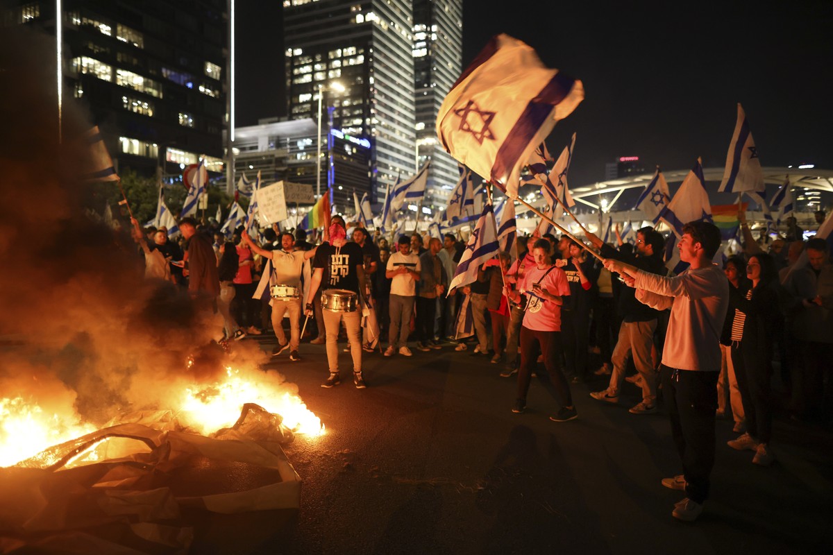 Israelis opposed to Prime Minister Benjamin Netanyahu's judicial overhaul plan set up bonfires and block a highway during a protest moments after the Israeli leader fired his defense minister, in ...