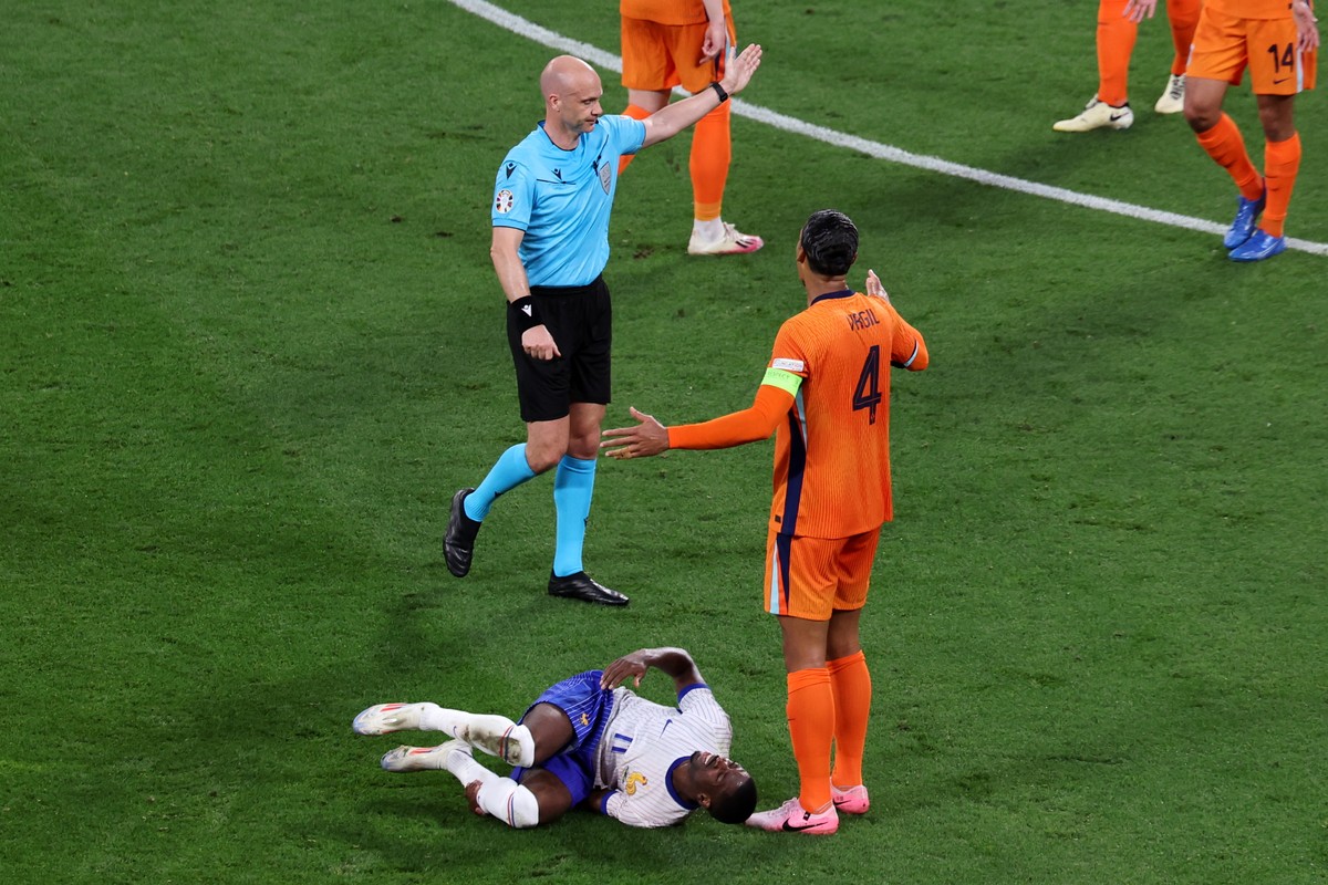 epa11429303 Referee Anthony Taylor (L) gestures for a foul on Virgil van Dijk of the Netherlands (R) against Ousmane Dembele of France (C) during the UEFA EURO 2024 Group D soccer match between the Ne ...