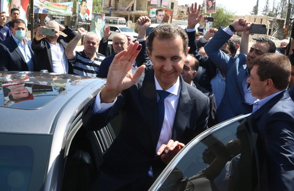 epaselect epa09228337 Syrian President Bashar al-Assad waves at supporters as he leaves a polling station in Duma city, outskirts of Damascus, Syria, on 26 May 2021. The city was liberated by the Syri ...