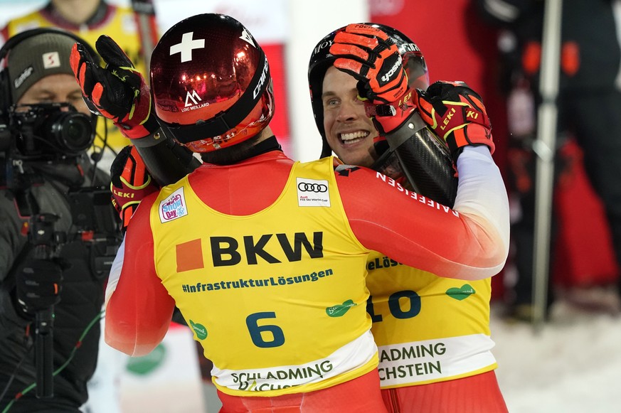 Switzerland's Gino Caviezel, second placed, right, and Switzerland's Loic Meillard, first placed, celebrate in the finish area of an alpine ski, men's World Cup giant slalom in Schladming, Austria, We ...