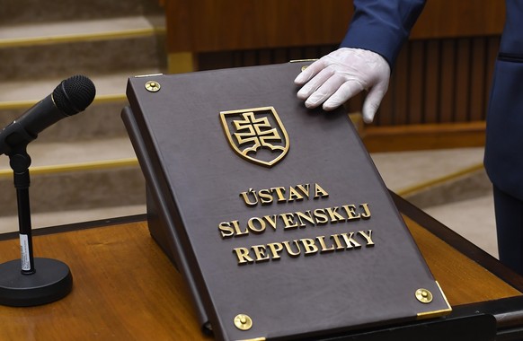 A member of parliament wearing gloves to prevent the spread of the coronavirus, takes the oath during the inaugural session of the new Parliament, in Bratislava, Slovakia, Friday, March 20, 2020. The  ...