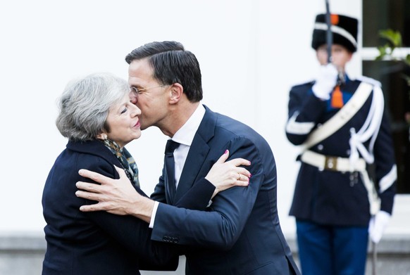 epa07223123 Dutch Prime Minister Mark Rutte (R) kisses British Prime Minister Theresa May as he welcomes her for a working breakfast at the Catshuis, in The Hague, The Netherlands, 11 December 2018. B ...