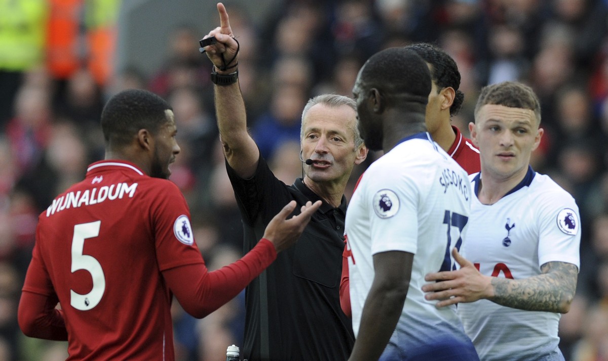 Referee Martin Atkinson, center, discusses with Liverpool's Georginio Wijnaldum, left, during the English Premier League soccer match between Liverpool and Tottenham Hotspur at Anfield stadium in ...
