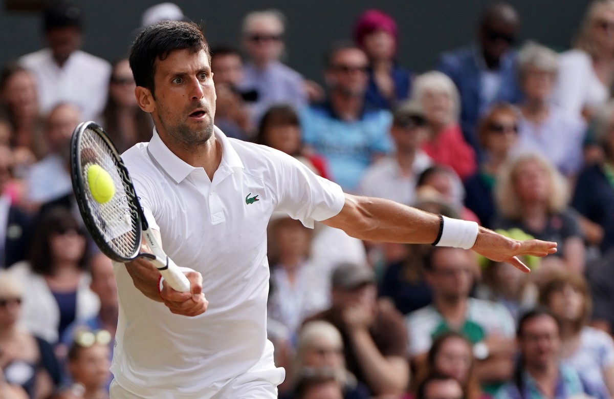 epaselect epa07717093 Novak Djokovic of Serbia returns to Roger Federer of Switzerland in the men's final of the Wimbledon Championships at the All England Lawn Tennis Club, in London, Britain, 1 ...