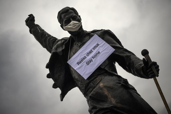 A statue of Freddie Mercury wearing a surgical mask and a sign &quot;stay home&quot; stand on a square in Montreux, Switzerland, Monday, March 23, 2020. Like other European countries Switzerland is hi ...