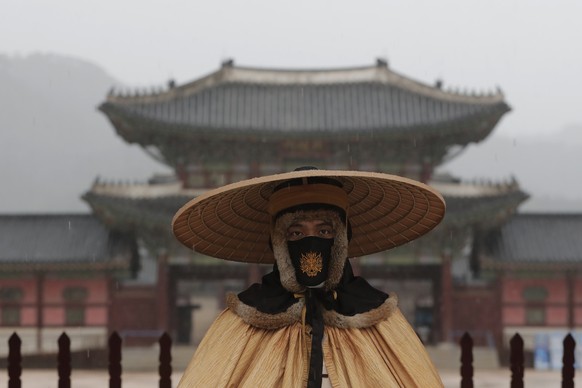 An Imperial guard wearing a face mask to help protect against the spread of the coronavirus stands outside the Gwanghwamun, the main gate of the 14th-century Gyeongbok Palace, in Seoul, South Korea, M ...