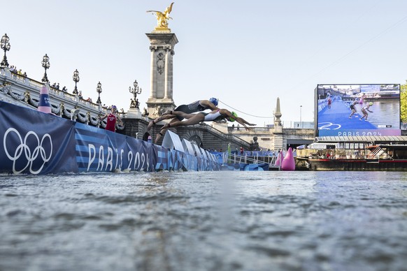 Athletes jump into the water to compete in the swimming race in the Seine river, during the mixed relay triathlon, at the 2024 Olympic Games, in Paris, France, Monday, Aug. 5, 2024. (Martin Bureau/Poo ...