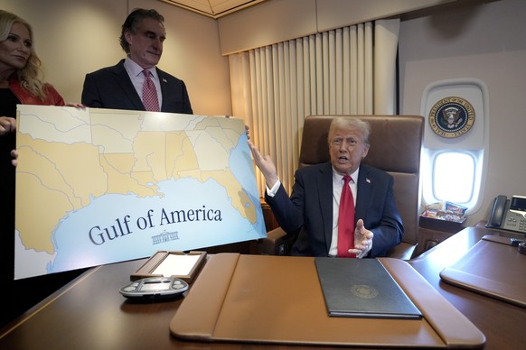 President Donald Trump, from right, speaks to reporters accompanied by Interior Secretary Doug Burgum and Burgum&#039;s wife Kathryn Burgum, aboard Air Force One where Trump signed a proclamation decl ...