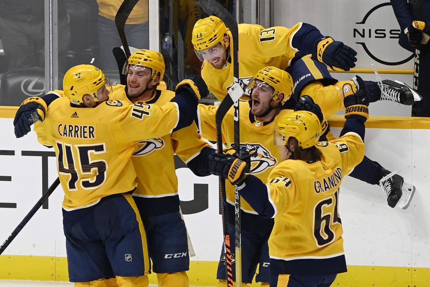 Nashville Predators defenseman Alexandre Carrier (45) celebrates with teammates after scoring a goal against the Edmonton Oilers in overtime of an NHL hockey game, Monday, Dec. 19, 2022, in Nashville, ...