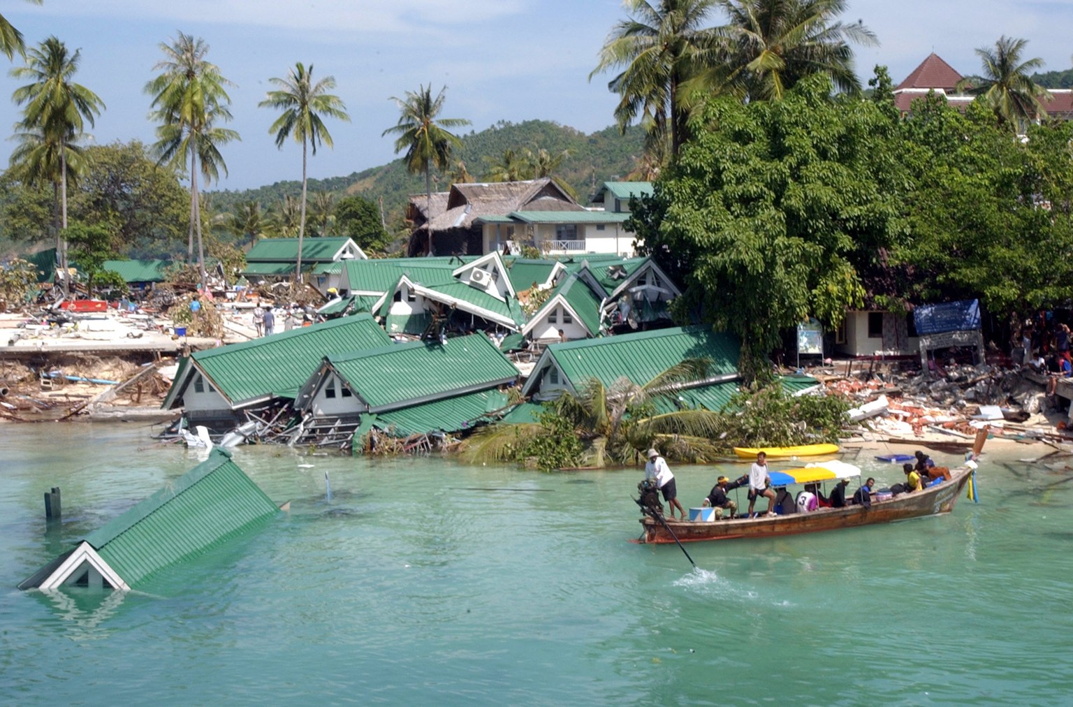 FILE - In this Dec. 28, 2004 file photo, a boat passes by a damaged hotel, at Ton Sai Bay on Phi Phi Island, in Thailand. Friday marks the 10th anniversary of one of the deadliest natural disasters in ...