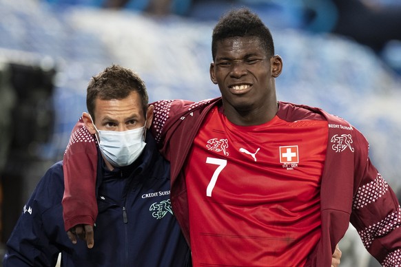 epa08651633 Switzerland&#039;s Breel Embolo walks off the pitch with a medical staff member after being injured during the UEFA Nations League group 4 soccer match between Switzerland and Germany at t ...