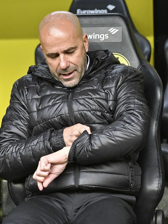 Dortmund&#039;s head coach Peter Bosz, right, looks at his watch as he sits beside sporting manager Michael Zorc, left, prior to the German Bundesliga soccer match between Borussia Dortmund and FC Sch ...