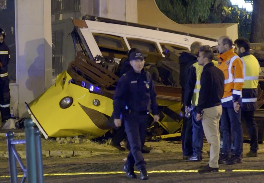 In this image taken from video, emergency service personnel work at the scene of a tram accident, Friday, Dec. 14, 2018, in Lisbon, Portugal. Portuguese emergency services say a Lisbon tram has derail ...