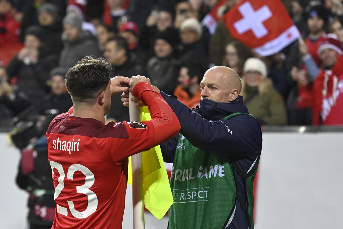 Switzerland's midfielder Xherdan Shaqiri, left, replaces the corner flag with Switzerland's fitness coach Oliver Riedwyl, right, during the 2022 FIFA World Cup European Qualifying Group C ma ...