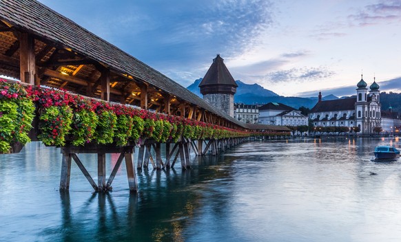 Chapel Bridge across lake Lucerne with the Jesuit church on the banks of the lake.