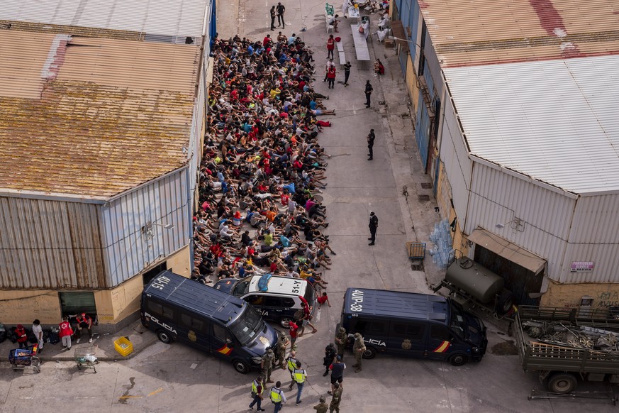 Unaccompanied minors who crossed into Spain are gathered outside a warehouse used as temporary shelter as they wait to be tested for COVID-19 at the Spanish enclave of Ceuta, near the border of Morocc ...