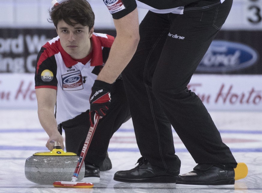 Switzerland fourth Benoit Schwarz makes a shot as third Claudio Patz sweeps during the 8th draw against Russia at the Men&#039;s World Curling Championships in Edmonton, Monday, April 3, 2017. (Jonath ...