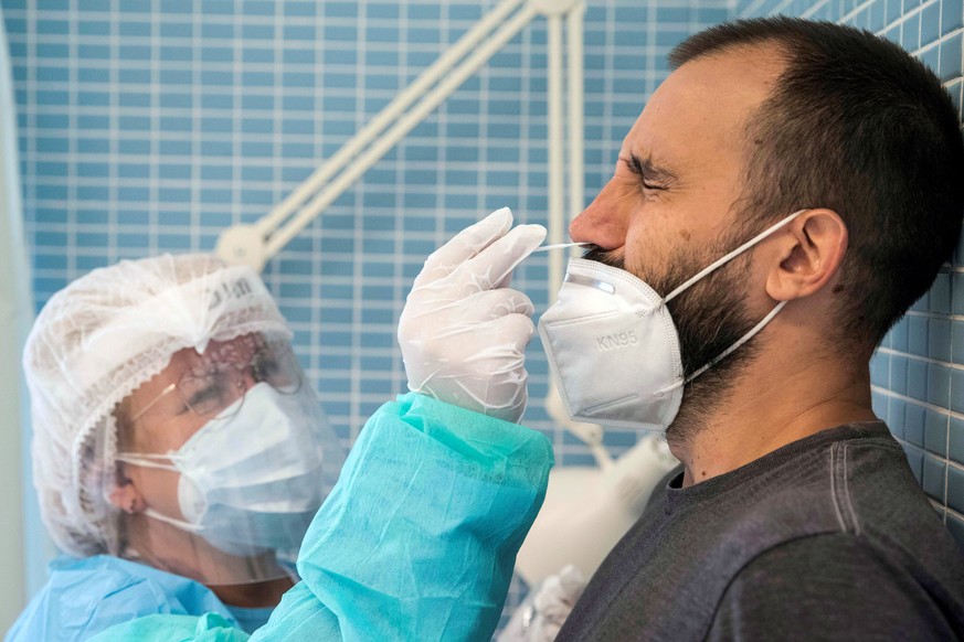 epa08639399 A health worker takes a swab sample from a man for a coronavirus PCR test in a health center in Murcia, Spain, 01 September 2020. EPA/Marcial Guillén