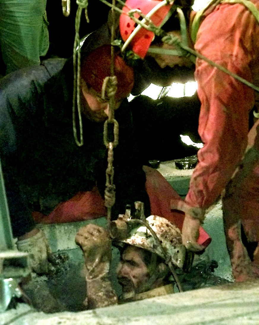 Yvon Casal, with white helmet, is pulled to the surface after being rescued from a cave in Gramat, southwestern France, early Monday, November 22, 1999. Casal was one of seven cave explorers reached b ...