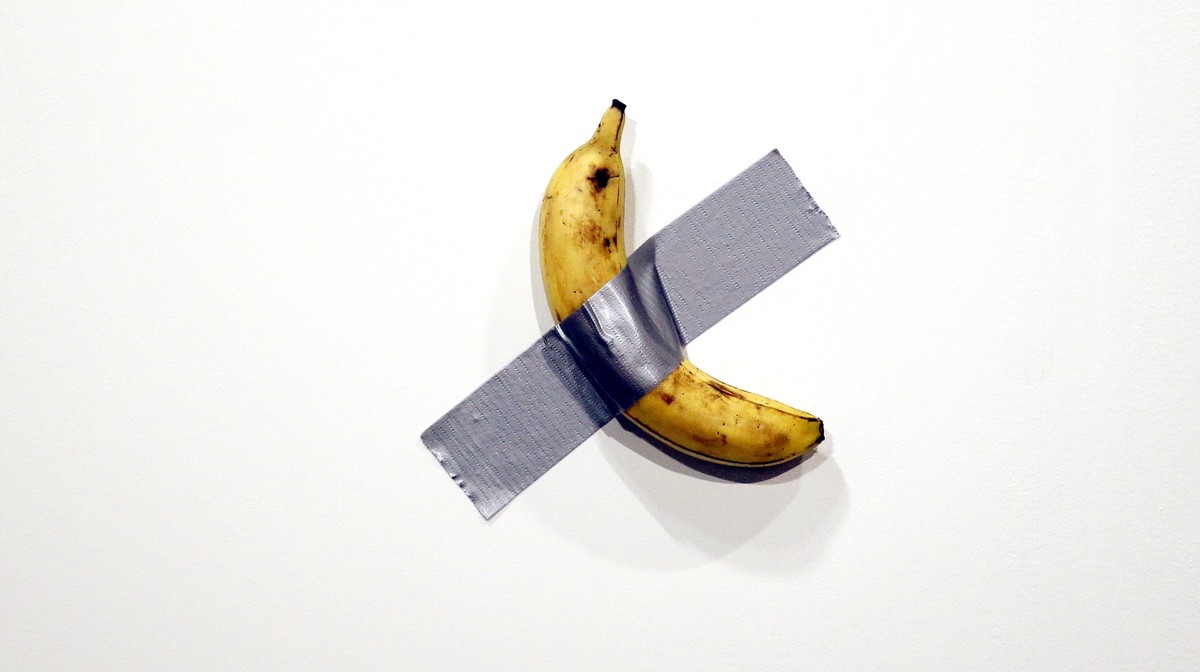 epaselect epa08047501 Italian artist Maurizio Cattelan's piece 'Comedian' (a banana duct taped to the wall) is shown during Art Basel in Miami, Florida, USA, 05 December 2019. Art Basel ...