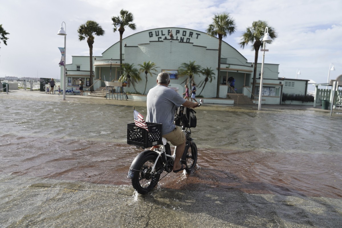 Louis Ward, 57, rides his bike along the the Gulfport waterfront as it takes on water as Hurricane Helene makes its way toward the Florida Panhandle, Thursday, Sept. 26, 2024 in Gulfport. (Martha Asen ...
