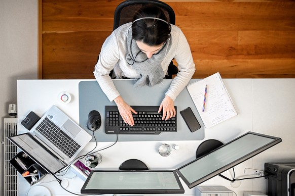 epaselect epa08933122 A woman with a headset sits in front of her computer in the study at home in Moenchengladbach, Germany, 12 January 2021. In view of the fact that the number of corona infections ...