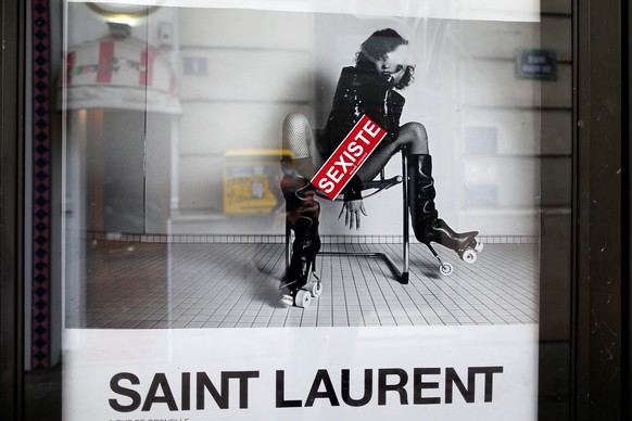 A sticker which reads &quot;sexist&quot; is seen on an ad by French fashion house Yves Saint Laurent displayed on a newspaper kiosk in Paris, France, March 6, 2017. France&#039;s advertising watchdog  ...