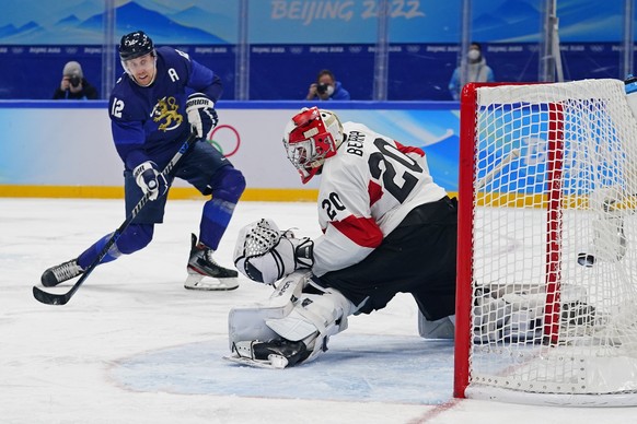 Finland&#039;s Marko Anttila (12) scores a goal against Switzerland goalkeeper Reto Berra (20) during a men&#039;s quarterfinal hockey game at the 2022 Winter Olympics, Wednesday, Feb. 16, 2022, in Be ...