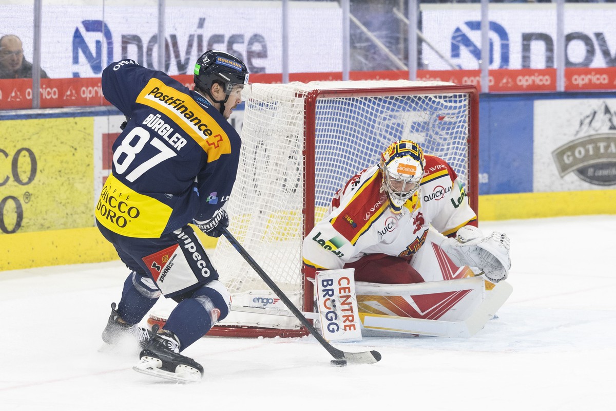 Ambri's player Dario Buergler, left, fights for the puck with Bienne's goalkeeper Harri S�teri, right, during the preliminary round game of National League Swiss Championship 2023/24 between ...
