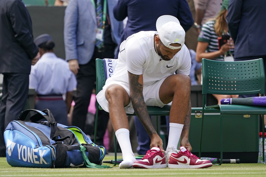 Australia&#039;s Nick Kyrgios takes off his red shoes and puts on his white match ones before his fourth round men&#039;s singles match against Brandon Nakashima of the United States on day eight of t ...