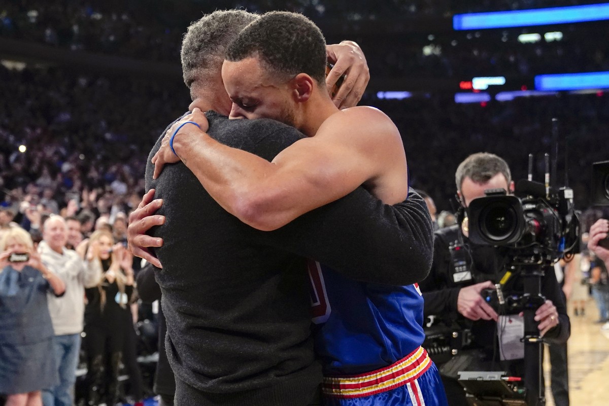 Golden State Warriors guard Stephen Curry hugs his father Dell Curry after scoring a three-point basket during the first half of an NBA basketball game against the New York Knicks, Tuesday, Dec. 14, 2 ...