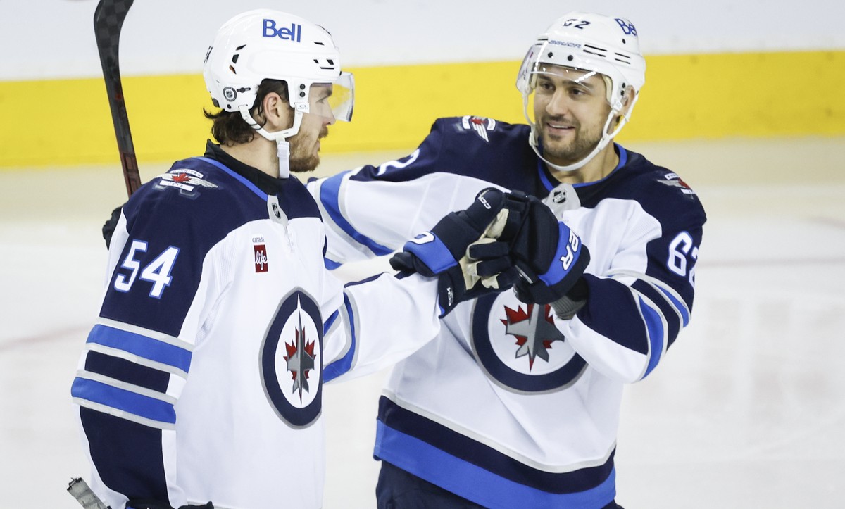 Winnipeg Jets' Dylan Samberg, left, celebrates after his goal with teammate Nino Niederreiter during third-period NHL hockey game action against the Calgary Flames in Calgary, Alberta, Saturday,  ...