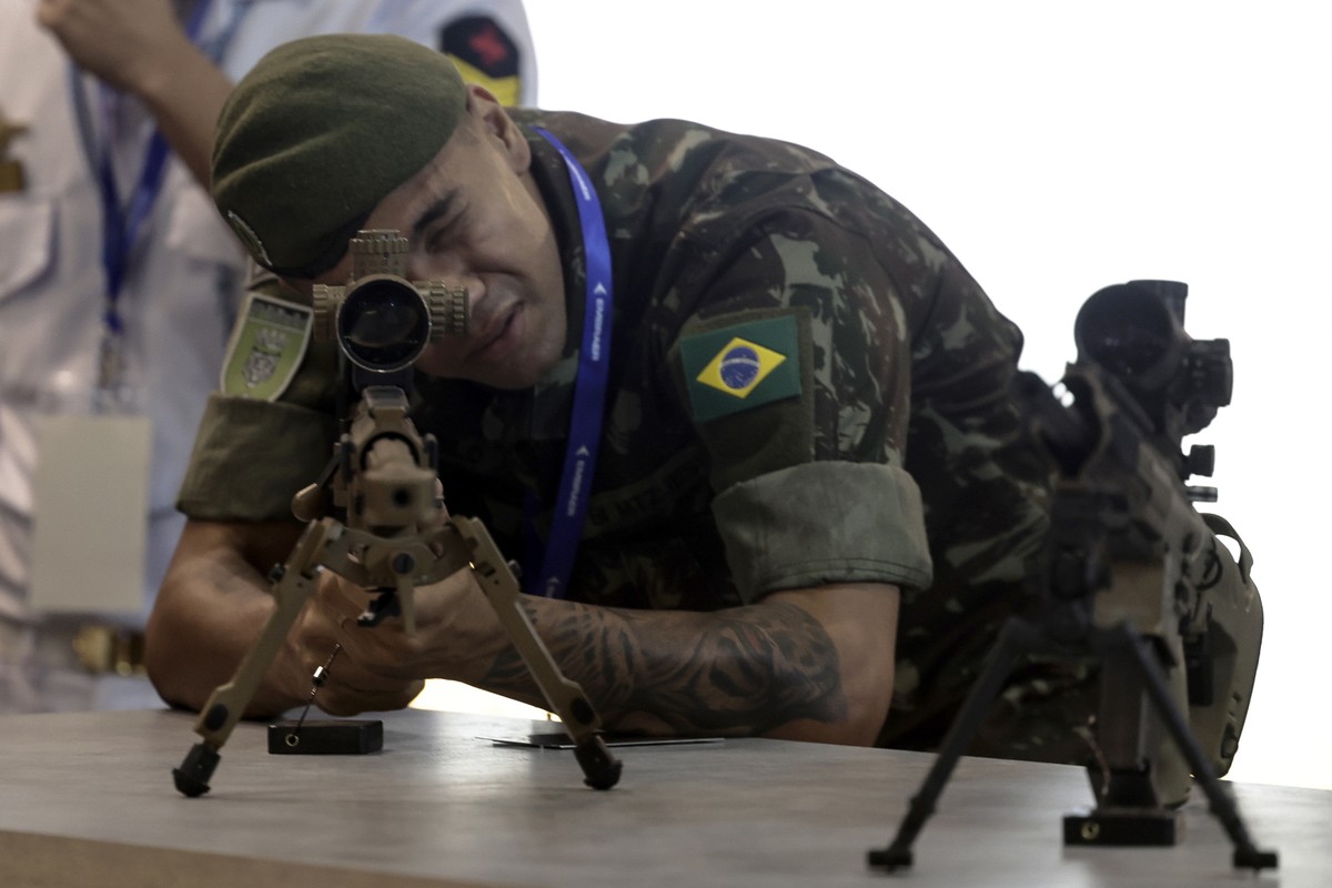 epa10568981 A man handles a weapon on display at the LAAD International Defense and Security Exhibition in Rio de Janeiro, Brazil 11 April 2023. The largest defense and security exhibition in Latin Am ...