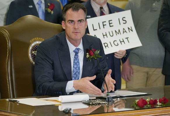 FILE - Oklahoma Gov. Kevin Stitt speaks after signing into law a bill making it a felony to perform an abortion, punishable by up to 10 years in prison, on. April 12, 2022, in Oklahoma City. Stitt on  ...