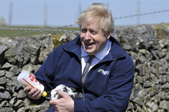 Britain&#039;s Prime Minister Boris Johnson feeds a lamb at Moor Farm in Stoney Middleton, England, Friday, April 23, 2021, as part of a Conservative party local election visit. (AP Photo/Rui Vieira,  ...