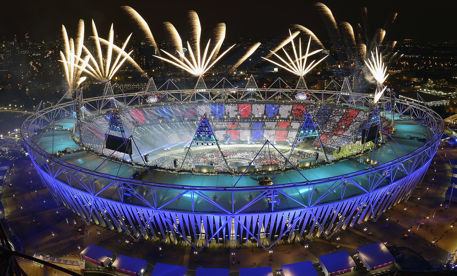 FILE - In this July 28, 2012, file photo, fireworks illuminate the sky over the Olympic Stadium during Opening Ceremonies at the 2012 Summer Olympics in London. Always splashy affairs, the parade of a ...