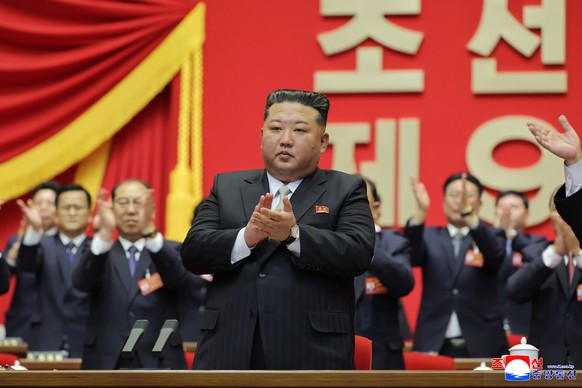 epaselect epa12770554 A photo released by the official North Korean Central News Agency (KCNA) shows North Korean leader Kim Jong Un (C) and officials applauding during the fourth day of the Ninth Con ...