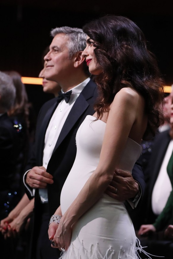 epa05813425 US actor George Clooney (L) and his wife Amal Clooney (R) react during the 42nd annual Cesar awards ceremony held at the Salle Pleyel concert hall in Paris, France, 24 February 2017. EPA/I ...