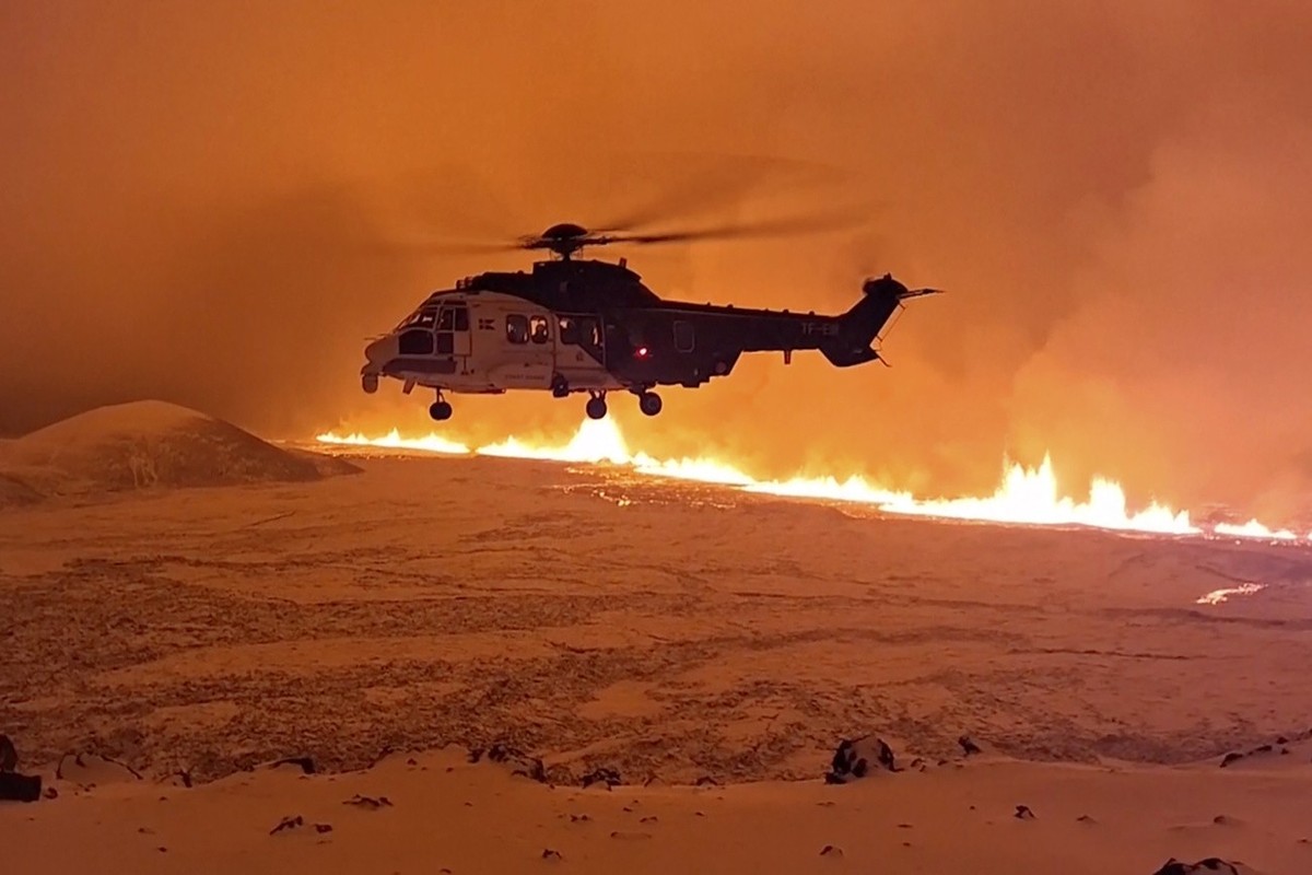 This image made from video provided by the Icelandic Coast Guard shows its helicopter flying near magma running on a hill near Grindavik on Iceland's Reykjanes Peninsula sometime around late Mond ...
