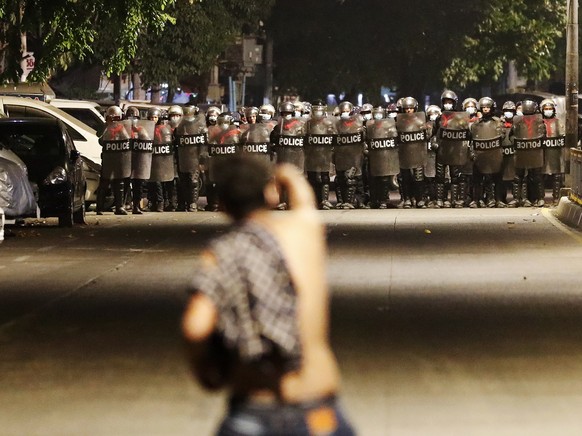 epa09711502 (25/31) (FILE) - A demonstrator gestures at anti-riot police during a protest in Yangon, Myanmar, 25 February 2021 (reissued 27 January 2022). On 01 February 2021 the Myanmar Army arrested ...