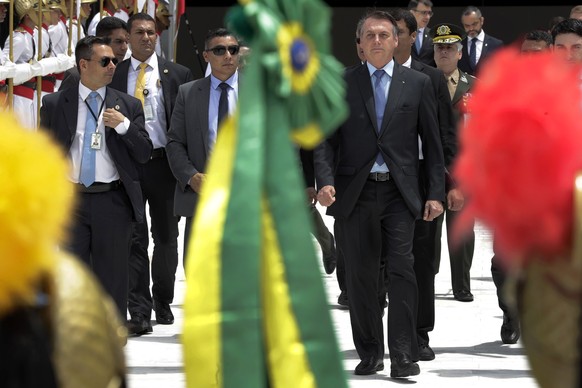 Brazil&#039;s President Jair Bolsonaro walks to greet supporters at the end of a Changing of the Guard at the Planalto Presidential Palace, in Brasilia, Brazil, Thursday, Nov. 28, 2019. (AP Photo/Eral ...