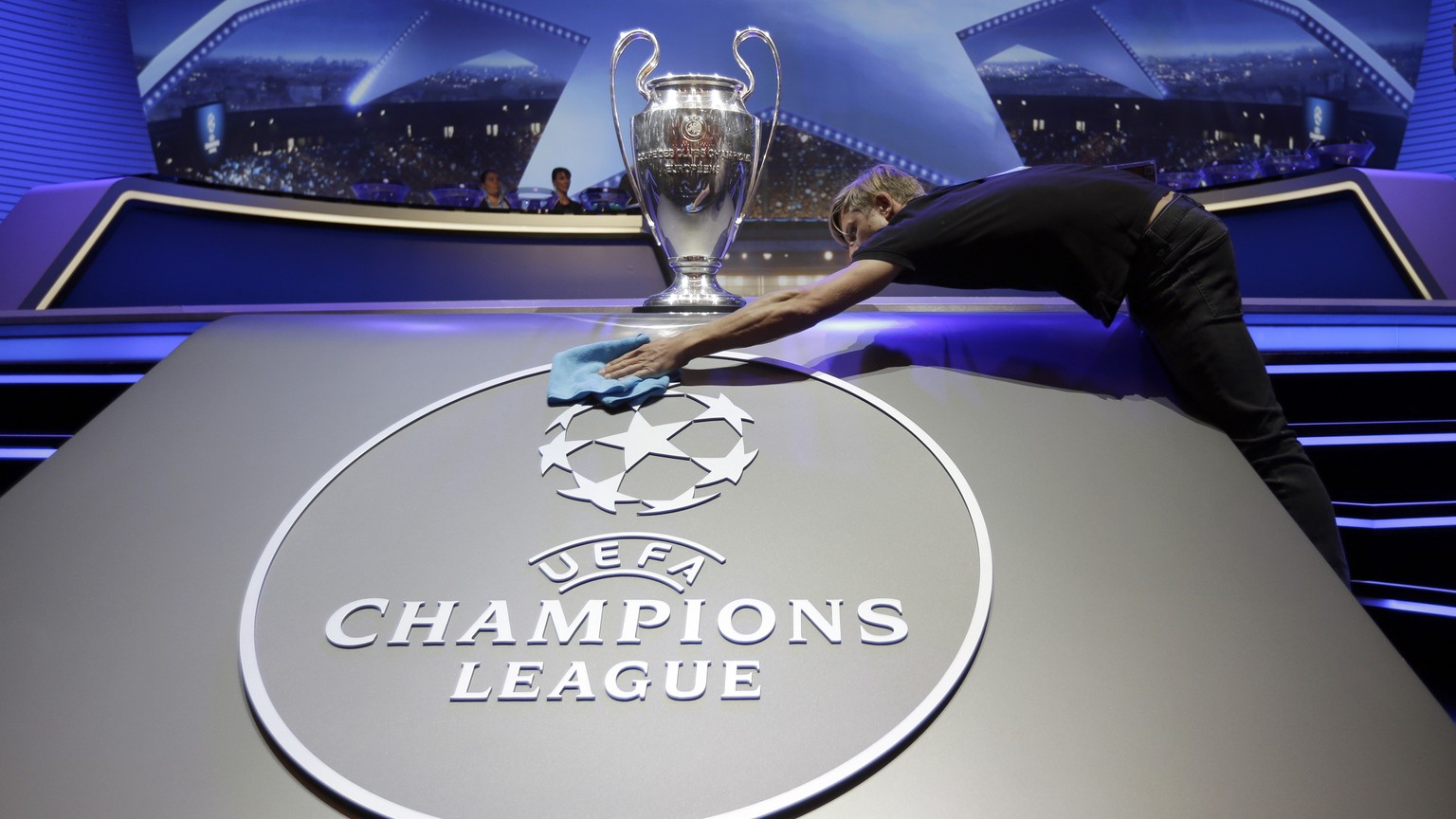 A man cleans the logo of UEFA Champions League before the UEFA Champions League draw at the Grimaldi Forum, in Monaco, Thursday, Aug. 24, 2017. (AP Photo/Claude Paris)