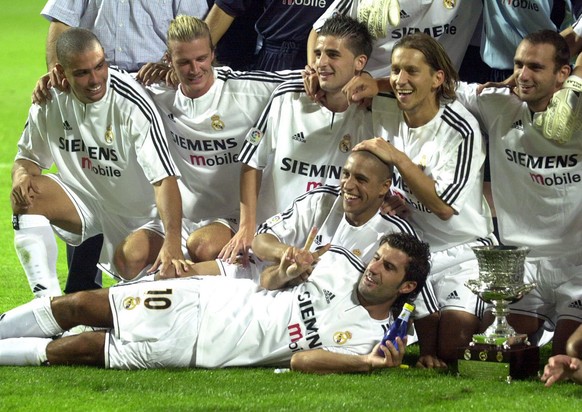 A part of the Real Madrid team, including Ronaldo, left, David Beckham, second left, Luis Figo, bottom, and Roberto Carlos, second bottom, pose with the trophy after winning the Supercup by beating Ma ...