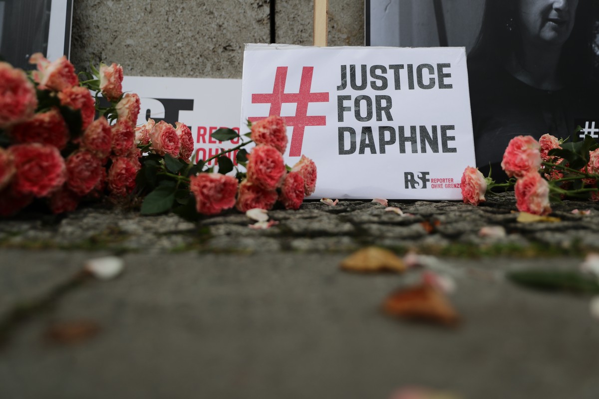 epa08749854 Flowers and placards reading 'Justice for Daphne' are seen at a vigil on the third anniversary of the murder of the Maltese investigative journalist Daphne Caruana Galizia in fro ...