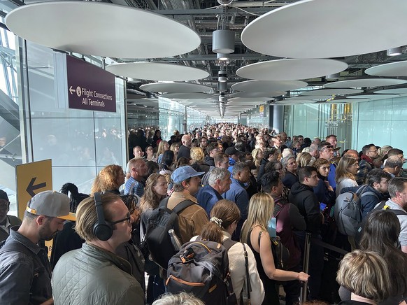 People queue at arrivals at Heathrow airport in London, Saturday, May 27, 2023. The British government is working to fix a technical problem that caused electronic border gates at airports around the  ...